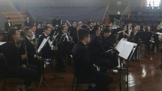 Músicos y músicas de la Banda de Conciertos de Cartago, sentados interpretando la música de su concierto.