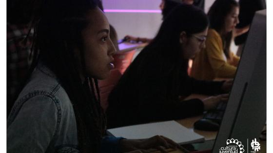 Jóvenes prestando atención a lo que hacen mientras observan la computadora
