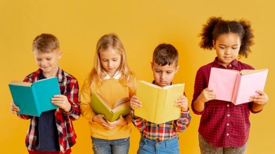 Cuatro niños de diferentes edades con un libro en la mano