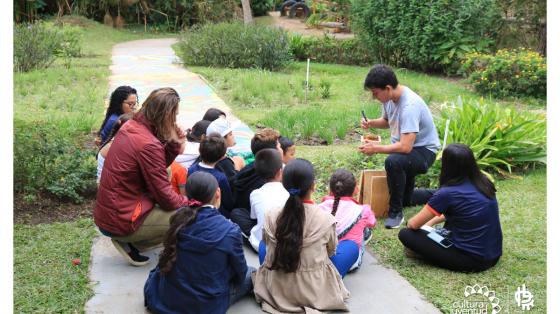 Un instructor explicando a varios niños sobre la alimentación y reproducción de especies
