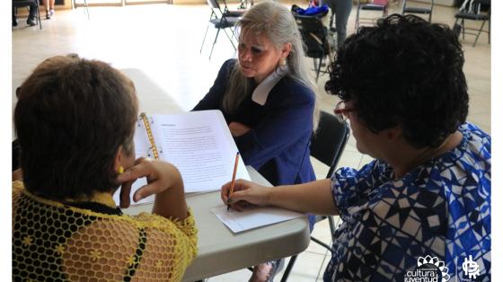 Tres personas en una mesa aprendiendo a aplicar un nuevo proceso