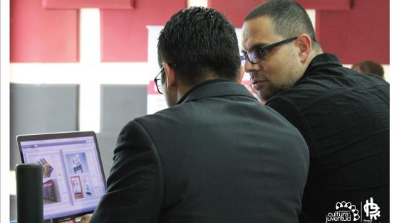 Dos personas analizando y conversando mientras están frente a una computadora