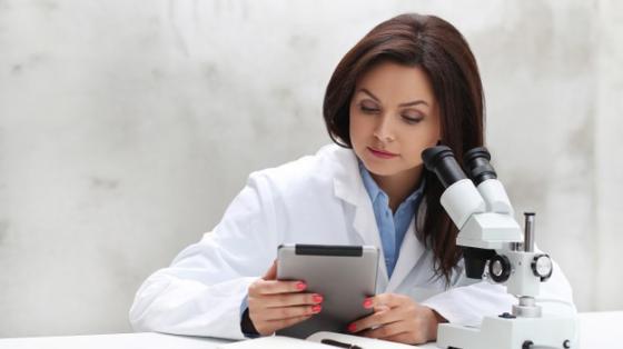 Mujer trabajando en un laboratorio con un microscopio