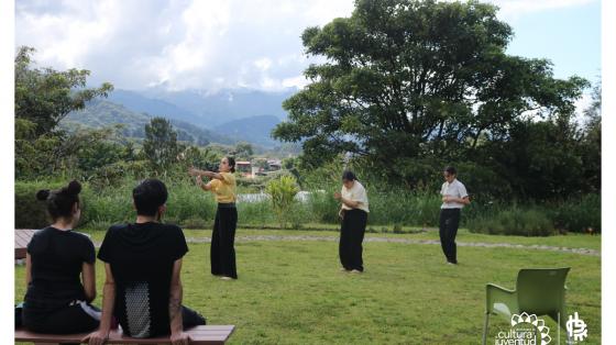 Tres jóvenes realizando una presentación de danza contemporánea en los jardines de la Escuela de Danza, Teatro y Circo
