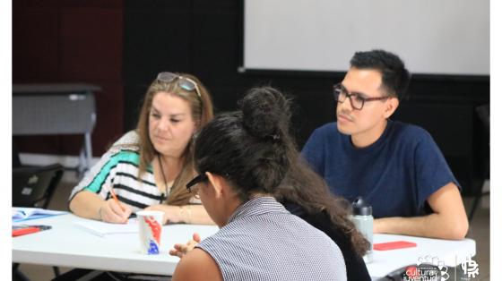 Tres personas prestando atención en una charla