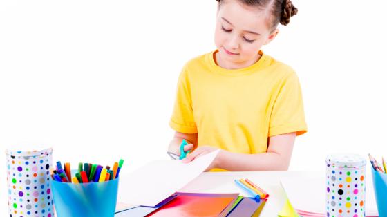 Manualidad, regalo para papá Niña recortando papel para hacer una manualidad.