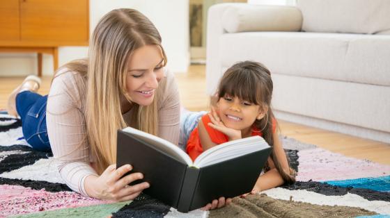 Madre e hija leyendo un libro.