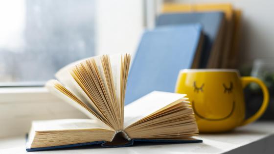 Libro abierto y una taza de café. 