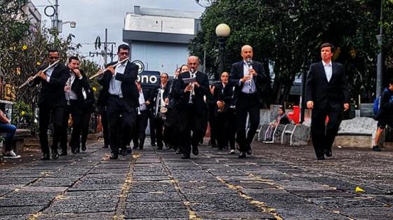 foto de los músicos de la Banda de Heredia en procesión por el parque