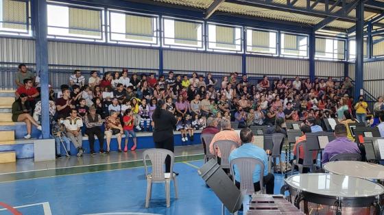 Concierto Didáctico - Banda de Conciertos de Cartago Foto de los músicos en un gimnasio ofreciendo un concierto a público infantil