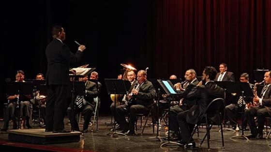 Foto de los músicos de la Banda vestidos elegantemente en un teatro