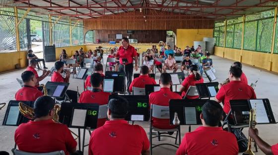 Foto de la Banda de Guanacaste en un concierto didáctico con niñas y niños al fondo