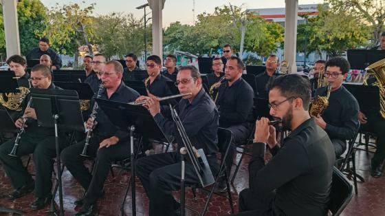 Músicos vestidos elegantemente de negro tocando en el quiosco del parque de Liberia