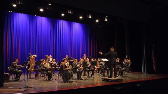 Banda de Conciertos de Guanacaste en el escenario de un teatro con fondo azul