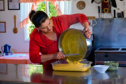 Gastronomía costarricense, mujer cocinando Mujer vertiendo contenido de un molde para crear torta de novios