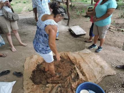 Ella da clases sobre la técnica para trabajar el barro, cómo se extrae, se seca, se pila y mezcla luego con la arena. Aquí en un taller en Isla de Chira. Fotografía cortesía de Zeneida Trejos Rosales para el CICPC.