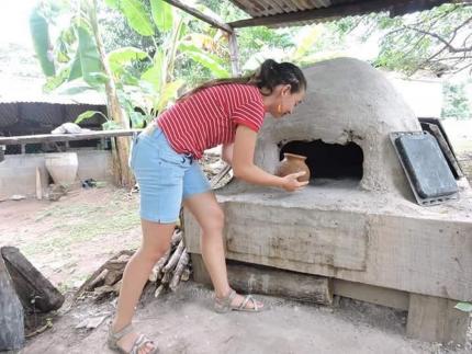 Una de sus pupilas en Isla de Chira pone una pieza a hornear como parte de un taller que impartió. Fotografía cortesía de Zeneida Trejos Rosales para el CICPC.