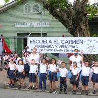 Niños y niñas de la Escuela El Carmen frente al edificio 