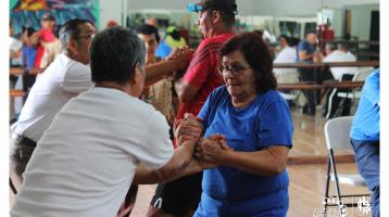 Adultos mayores haciendo ejercicio en un salón 