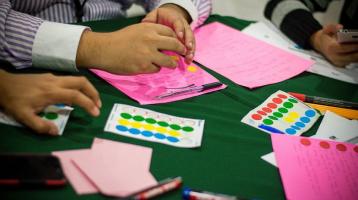 jóvenes trabajando en mesas tipo taller
