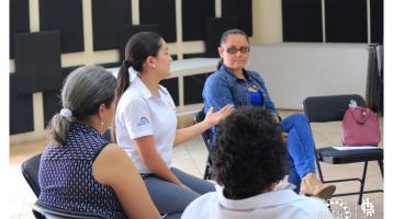 Personas escuchando a una muchacha impartir una charla