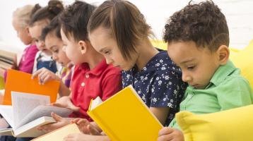 Grupo de niños y niñas leyendo. 