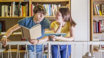 Adolescentes leyendo en la biblioteca.