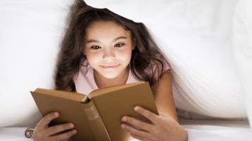 Niña leyendo un libro.