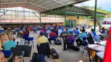 Foto de la Banda de Conciertos de Cartago tocando en el gimnasio de una escuela