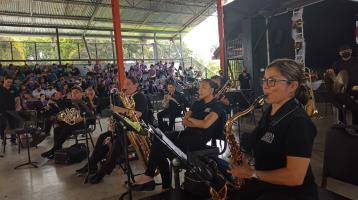 Foto de músicas y músicos en un gimnasio de colegio