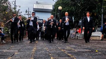 foto de los músicos de la Banda de Heredia en procesión por el parque