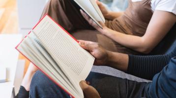 Dos personas jóvenes leyendo libros.