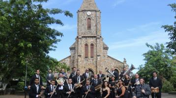 Músicos de la Banda de Conciertos de Puntarenas posando con la catedral de Puntarenas de fondo