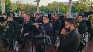 Músicos vestidos elegantemente de negro tocando en el quiosco del parque de Liberia